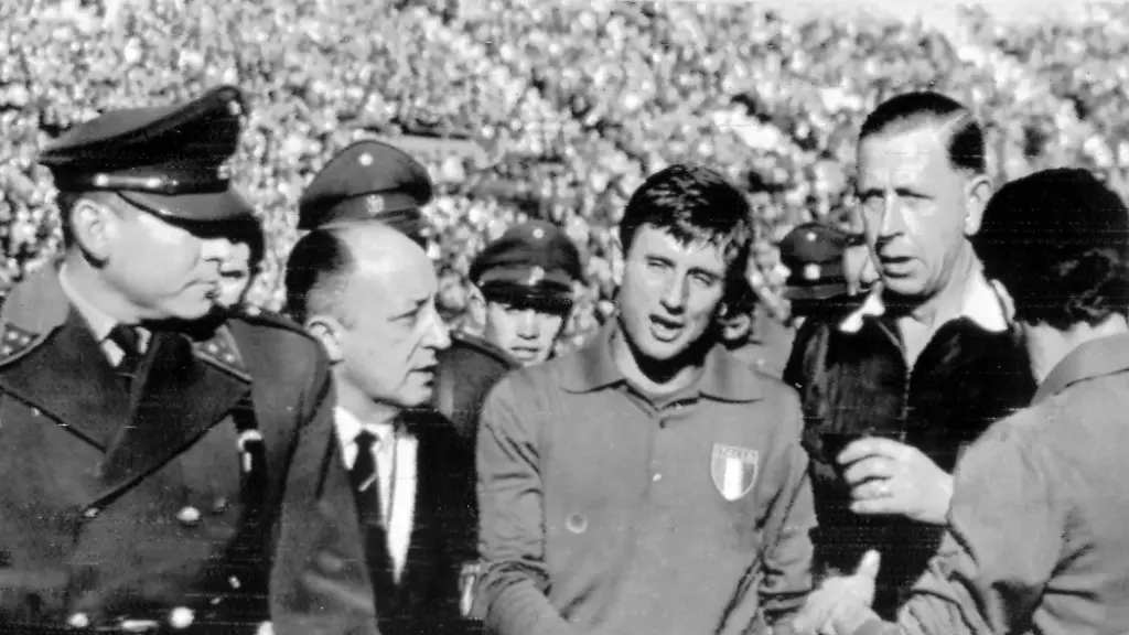 1962-World-Cup-Italy-v-Chile-Police-and-referee-Ken-Ashton-escort-Italian-player-Giorgio-Ferrini-from-the-field-Heated-quarrels-broke-out-between-players-of-the-two-teams-and-police-finally-had-to-come-onto-the-pitch-to-escort-Ferrini-off