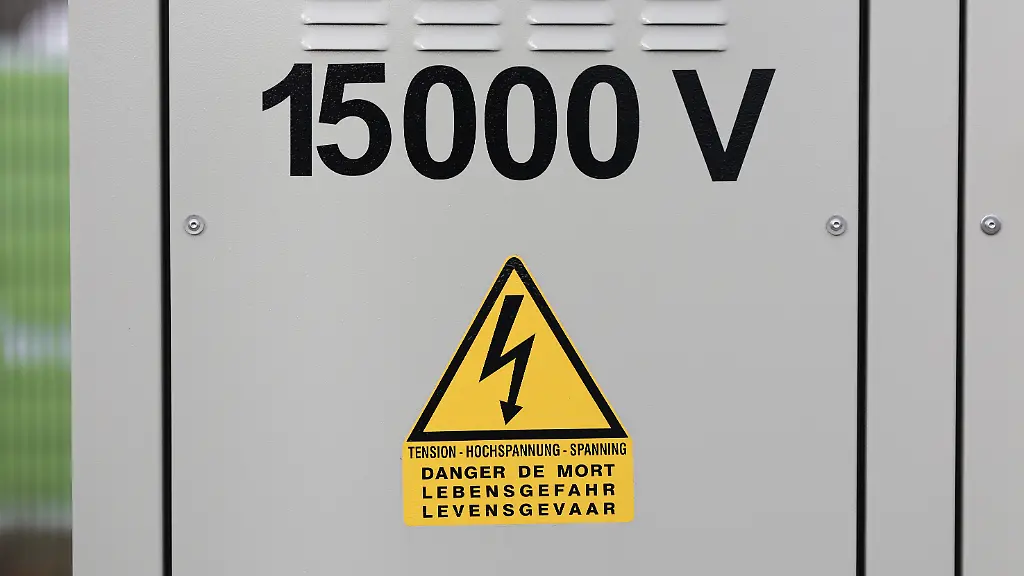 Blick-auf-einen-Batteriespeicher-der-Firma-EDF-Renewables-Deutschland-GmbH-mit-der-Aufschrift-15000-V-und-Hochspannung-Der-2024-installierte-Batteriespeicher-wird-in-Kooperation-mit-der-Hassender-Brauerei-GmbH-betrieben