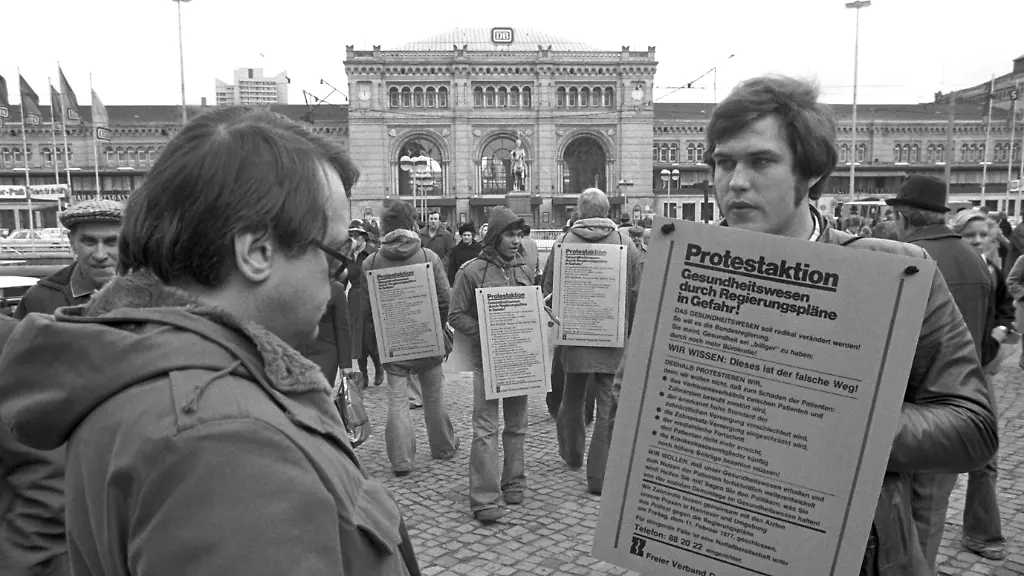 Mit-lebenden-Plakattafeln-informierten-Aerzte-und-Zahnaerztverbaende-am-11-02-1977-ueber-ihre-Protestaktion-vor-dem-Hauptbahnhof-in-Hannover-Aus-Protest-gegen-das-von-der-Bundesregierung-geplante-Gesetz-die-Krankenversicherungskosten-zu-daempfen-wollten-die-Aerzte-und-die-Zahnaerzte-am-11-02-1977-in-Hannover-und-der-Umgebung-ihre-Praxen-schliessen