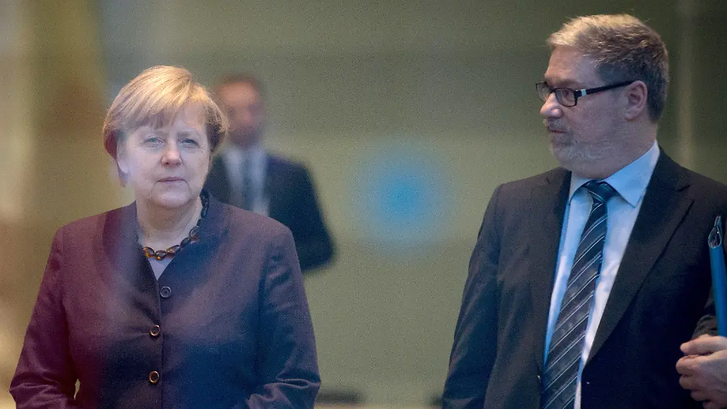 ARCHIV-Bundeskanzlerin-Angela-Merkel-CDU-steht-am-25-11-2015-in-Berlin-im-Bundeskanzleramt-zusammen-mit-ihrem-wirtschaftspolitischen-Berater-Lars-Hendrik-Roeller-r-Foto-Kay-Nietfeld-dpa-ACHTUNG-Die-Aufnahnme-wurde-durch-eine-Glasscheibe-gemacht-zu-dpa-Merkels-Sherpa-oder-Gipfelkunst-namens-Roeller-vom-25-05