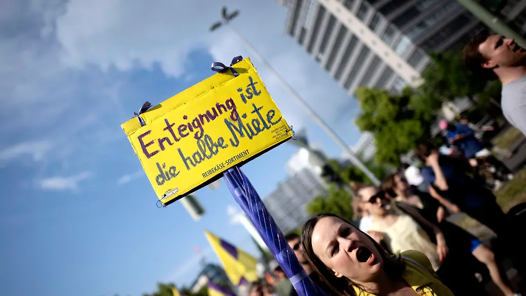 DEU-Deutschland-Germany-Berlin-01-06-2024-Demonstrant-mit-Plakat-Enteignung-ist-die-Halbe-Miete-auf-der-Demonstration-von-Mieterorganisationen-und-politischen-Initiativen-gegen-hohe-steigende-Mieten-Modernisierungen-Gentrifizierung-und-Zwangsraeumungen-unter-dem-Motto-Die-Miete-Ist-Zu-Hoch-und-Gegen-Verdraengung-Mieten-Wahnsinn-stoppen-auf-der-Demonstration-und-Kundgebung-in-Berlin-Deutschland-Eine-Demo-fuer-die-Unterstuetzung-der-Kampagne-Deutsche-Wohnen-und-CO-und-Vonovia-Enteignen-en-Protester-with-poster-Expropriation-is-half-the-battle-rent-at-the-demonstration-of-tenant-organizations-and-political-initiatives-against-high-rising-rents-modernizations-gentrification-and-forced-evictions-under-the-slogan-The-rent-is-too-high-and-against-displacement-at-the-demonstration-and-rally-in-Berlin-Germany-A-demo-to-support-the-German-Housing-and-CO-Expropriation-campaign