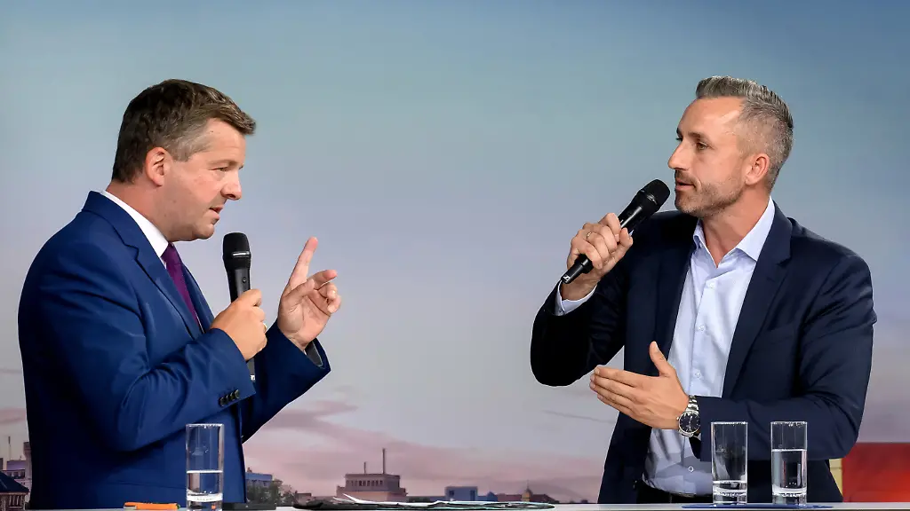 Sven-Schulze-l-CDU-Ministerpraesident-von-Sachsen-Anhalt-und-Ulrich-Siegmund-AfD-stehen-in-der-Hyparschale-in-Magdeburg-auf-der-Buehne-Dort-findet-das-Wahlforum-RND-vor-Ort-statt-bei-dem-die-Spitzenkandidaten-der-Parteien-bei-der-Landtagswahl-2026-ueber-unterschiedliche-Themen-diskutieren