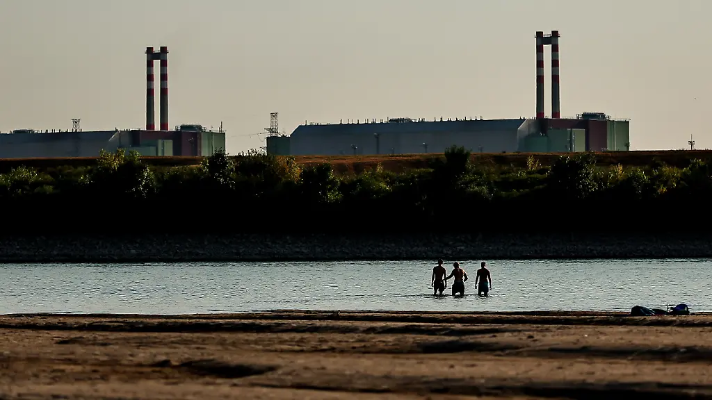 260803-BUDAPEST-Aug-3-2026-Xinhua-People-cool-off-in-the-Danube-River-with-the-Paks-nuclear-power-plant-in-the-background-near-Dunaszentbenedek-Hungary-Aug-2-2026-Hungary-is-entering-its-most-critical-5-days-as-dropping-water-levels-on-the-Danube-River-threaten-the-complete-shutdown-of-the-Paks-nuclear-power-plant-amid-an-extreme-heatwave-Hungary-s-Prime-Minister-Peter-Magyar-said-on-Sunday-warning-that-the-plant-could-be-shut-down-for-more-than-a-month