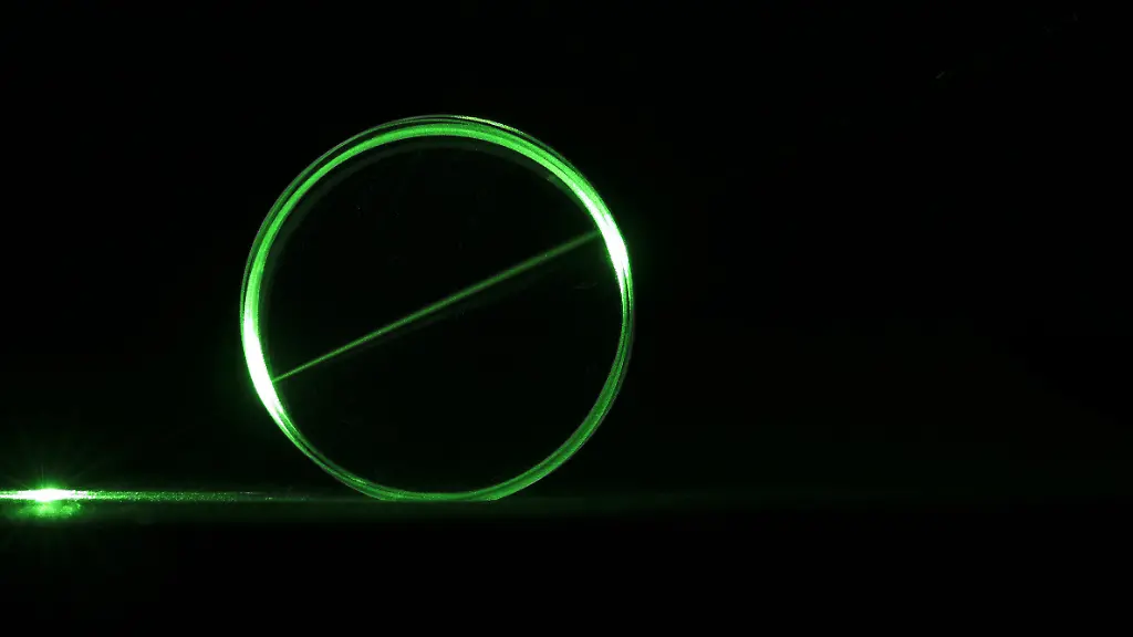 Ein-gruener-Laserstrahl-durchbricht-ein-rundes-Glasprisma