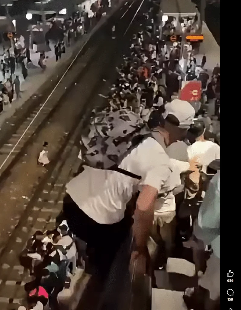 Videostandbild eines völlig überfüllten Bahnsteigs mit arabischen und französischen Beschriftungen; es handelt sich um den Bahnhof Kénitra in Marokko.
