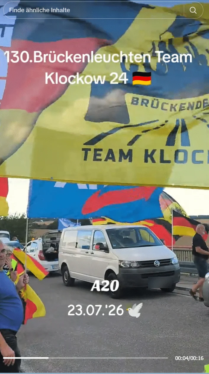 Standbild vom 23. Juli 2026: große Vereinsfahne der Gruppe an einem hohen Mast auf der Brücke